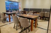 a dining room with tables and chairs and a large window at La Quinta by Wyndham Quito in Quito