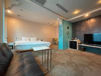 a hotel room with a bed and a couch and a tv at Yomi Hotel - ShuangLian MRT in Taipei