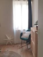 a living room with a chair and a window at Bel appartement, 2 chambres, centre ville in Thiers