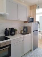 a kitchen with white cabinets and a white refrigerator at Bel appartement, 2 chambres, centre ville in Thiers