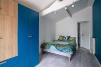 a bedroom with a bed and a blue wall at Maison de vacances Bisca in Biscarrosse