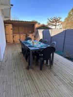 a black table and chairs on a deck at Maison de vacances Bisca in Biscarrosse