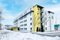 a yellow and white building in the snow at B&B HOTEL München-Airport in Hallbergmoos
