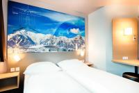 a hotel room with a bed and a picture on the wall at B&B HOTEL München-Airport in Hallbergmoos