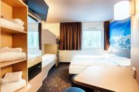 a hotel room with two beds and a table at B&B HOTEL München-Airport in Hallbergmoos