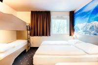 a hotel room with two beds and a window at B&B HOTEL München-Airport in Hallbergmoos