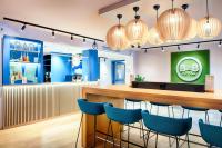 a bar in a restaurant with blue chairs at B&B HOTEL München-Airport in Hallbergmoos