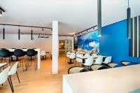 a dining room with white tables and chairs at B&B HOTEL München-Airport in Hallbergmoos