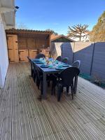 a black table and chairs on a wooden deck at Maison de vacances Bisca in Biscarrosse