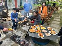 een groep mensen die rond een grill staan met eten bij Ninh Binh Bamboo Farmstay in Ninh Binh