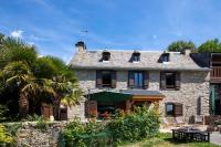 a stone house with a palm tree in front of it at Gîte d&#39;AURE. Classé en meublé 4 étoiles. 