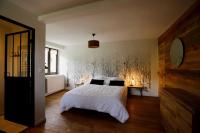 a bedroom with a bed with white sheets and black pillows at Gîte d&#39;AURE. Classé en meublé 4 étoiles. 