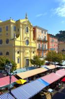 a large yellow building with a clock on it at Studio Climatisé dans villa bourgeoise in Nice