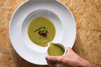a person holding a bowl of green soup at Imani Country House in Évora
