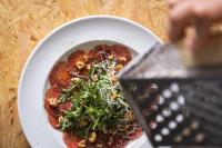 a person holding a spatula over a plate of pizza at Imani Country House in Évora