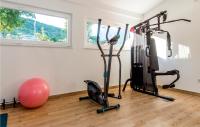 a gym with two treadmills and a exercise ball at Stunning Home In Siveric With 5 Bedrooms, Jacuzzi And Outdoor Swimming Pool in Siverić