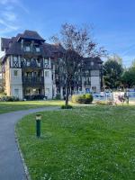 a large building with a trash can in the grass at Magnifique appartement 2 pièces in Deauville