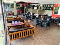 a restaurant with wooden tables and chairs and tables and tablesearcher at Hotel Gangaaddara in Kandy