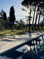 a group of tables and umbrellas next to a pool at La Pavoyère in Mormoiron