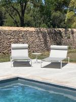 two chairs and a table next to a pool at La Pavoyère in Mormoiron