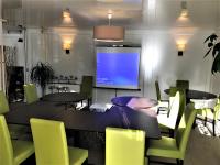 a dining room with a table and chairs and a tv at Hôtel-Restaurant La Mascotte in La Baule