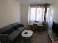 a living room with a couch and a table at Appartement meublé proche du centre - Wifi&#47;Parking in Clermont-Ferrand