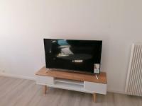 a flat screen tv sitting on top of a table at Appartement meublé proche du centre - Wifi&#47;Parking in Clermont-Ferrand