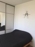 Schlafzimmer mit einem schwarzen Bett und einem Spiegel in der Unterkunft Chambre à louer 1 à 2 personnes chez l&#39;habitant in Saint-Herblain