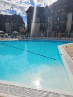 a large blue swimming pool in front of a building at Magnifique appartement 2 pièces in Deauville