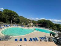 a large swimming pool with chairs and people in it at Superbe appartement 6pers avec piscine et jardin in Fréjus