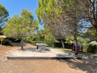 a park with a bench and a table and trees at Superbe appartement 6pers avec piscine et jardin in Fréjus