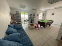 a living room with a couch and a pool table at Superbe appartement 6pers avec piscine et jardin in Fréjus