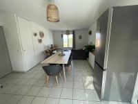 a kitchen and dining room with a table and a refrigerator at Superbe appartement 6pers avec piscine et jardin in Fréjus