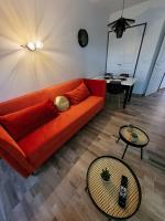 a living room with an orange couch and a table at Magnifique appartement 2 pièces in Deauville
