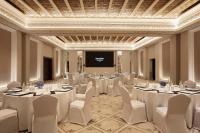 a room with white tables and chairs and a projection screen at Jumeirah Mina Al Salam Dubai in Dubai