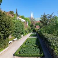 un parque con una hilera de setos y bancos en Picobello Pension, en Görlitz
