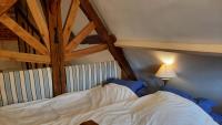 a bedroom with a white bed with a wooden ceiling at Le Parc aux Oiseaux in Le Mesnil-Simon