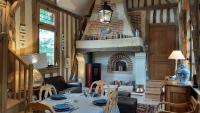 a dining room with a table and a fireplace at Le Parc aux Oiseaux in Le Mesnil-Simon