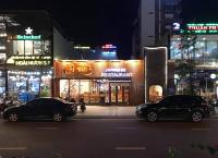 dois carros estacionados ao lado de uma rua à noite em FLC Quy Nhon Beachfront Condotel em Quy Nhon