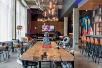 un restaurante con mesa de madera y sillas en Moxy Copenhagen Sydhavnen, en Copenhague