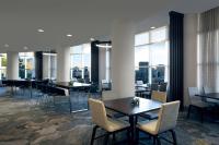 a dining room with tables and chairs and windows at Kansas City Marriott Country Club Plaza in Kansas City