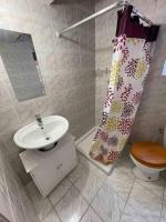 a bathroom with a sink and a toilet and a shower curtain at Chez dada in Grenoble