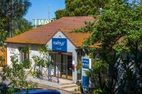 un pequeño edificio blanco con un cartel azul en Noemys ARLES, en Arles