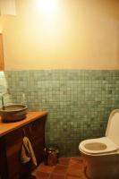 a green tiled bathroom with a toilet and a sink at Eco Lodge de Construção Natural com Vista Panorâmica in Nova Friburgo