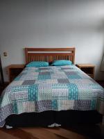 a bed with a quilt and two pillows on it at Eco Lodge de Construção Natural com Vista Panorâmica in Nova Friburgo