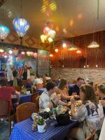 un grupo de personas sentadas en mesas en un restaurante en Napoli Hostel Cat Ba, en Cat Ba