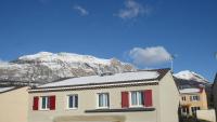 a house with red doors and a mountain in the background at appartement pas loin des montagnes in Gap