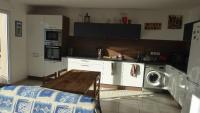 a kitchen with a table and a washing machine in it at appartement pas loin des montagnes in Gap