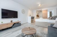 a white bedroom with a large bed and a table at Luni Apartment in Dubrovnik center in Dubrovnik