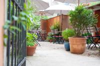 um pátio com vasos de plantas e mesas e um guarda-chuva em Pension Goldenes Schiff em Passau